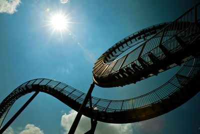 Low angle view of ferris wheel against blue sky