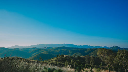 Scenic view of mountains against blue sky