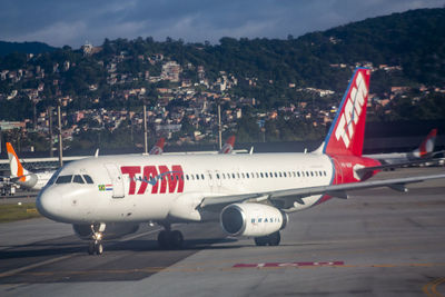 Airplane on airport runway against sky