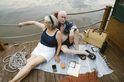 High angle view of senior couple sitting together on houseboat