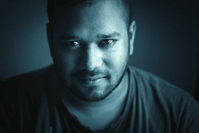 Close-up portrait of man against black background