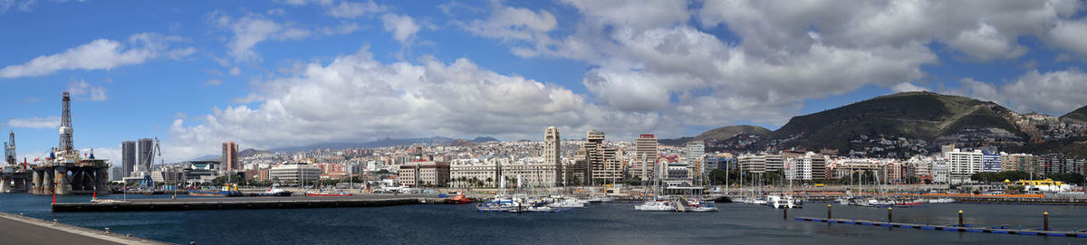 Panoramic view of city against cloudy sky