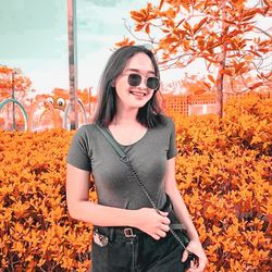 Young woman wearing sunglasses standing outdoors during autumn