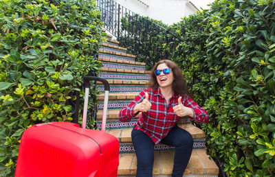 Smiling woman sitting by plants