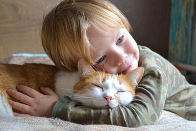 Portrait of a child aged four years old whit sleeping red cat