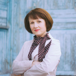 Portrait of mature woman standing against wall