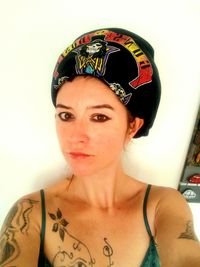 Portrait of young woman standing against wall