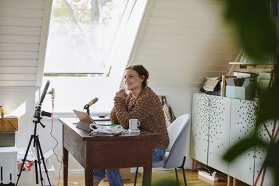 Woman sitting at desk and recording video