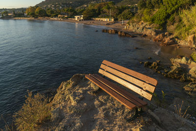 High angle view of bench on rock by river