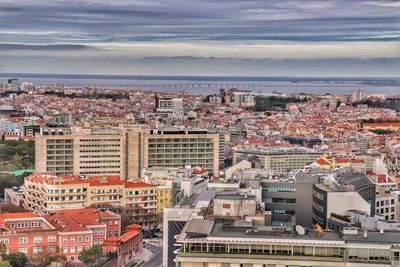 High angle view of townscape by sea against sky