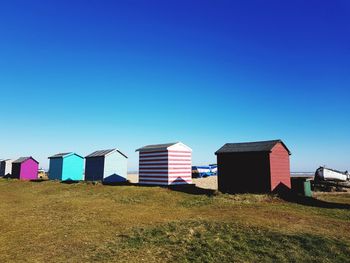 Houses on beach against clear blue sky