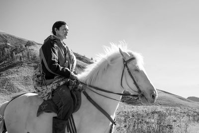 Low angle view of man riding horse against sky