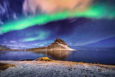 Scenic view of lake against sky at night