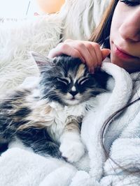 Midsection of woman relaxing with cat at home