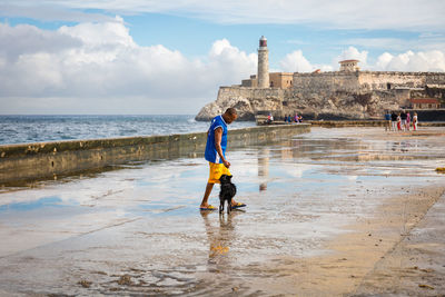 Man standing at beach against sky