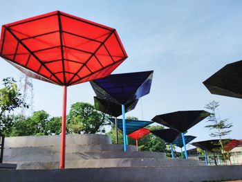 Red umbrella against sky in city