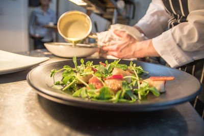 Close-up of man preparing food in plate