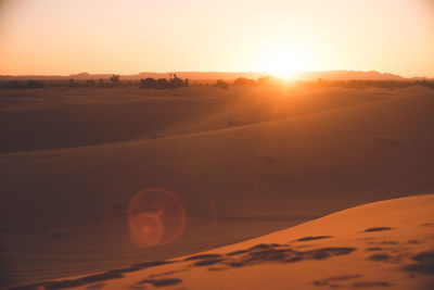 Morocco hassilabied sahara desert sunset over an oasis of sand dunes.