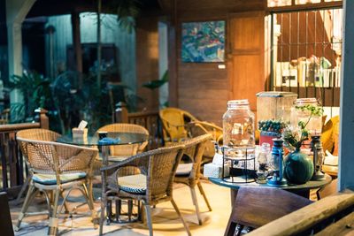 Empty chairs and tables at sidewalk cafe