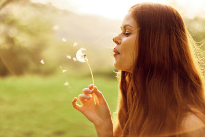 Young woman blowing bubbles at beach