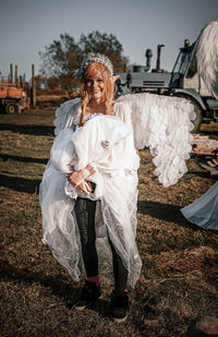 Full length of smiling woman wearing costume standing on field