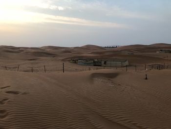 Sand dunes in desert against sky