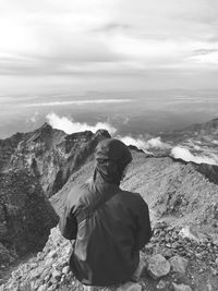 Rear view of man looking at mountain against sky