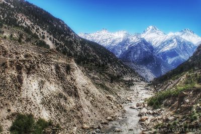 Scenic view of snowcapped mountains against clear blue sky