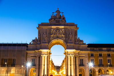 Low angle view of illuminated building against blue sky