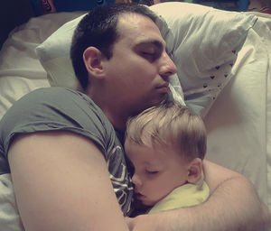 Close-up of baby boy sleeping on bed at home