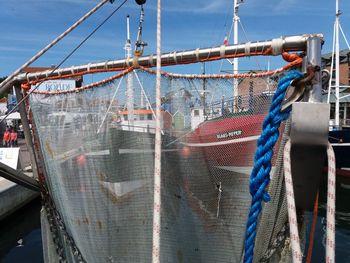 Boats moored at harbor against sky