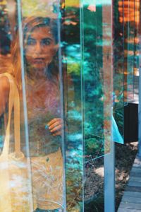 Portrait of young man looking through glass window