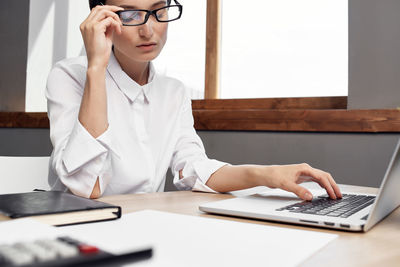 Man using mobile phone while sitting on table