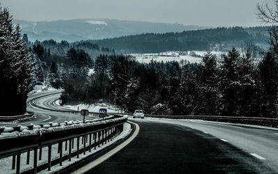 Road leading towards mountains during winter