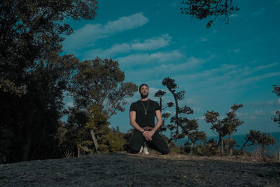 Man standing by tree against sky