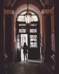 Rear view of woman standing in corridor of building