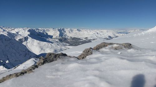 Scenic view of snowcapped mountains against clear blue sky