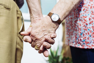 Back view of senior couple holding hands, close-up