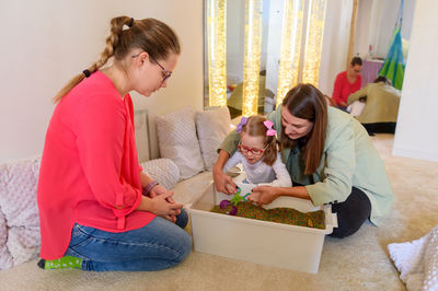 Child living with cerebral palsy interacting with her therapist during therapy session.