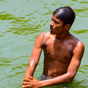 Full length of shirtless man in lake