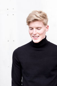 Portrait of smiling man standing against white background