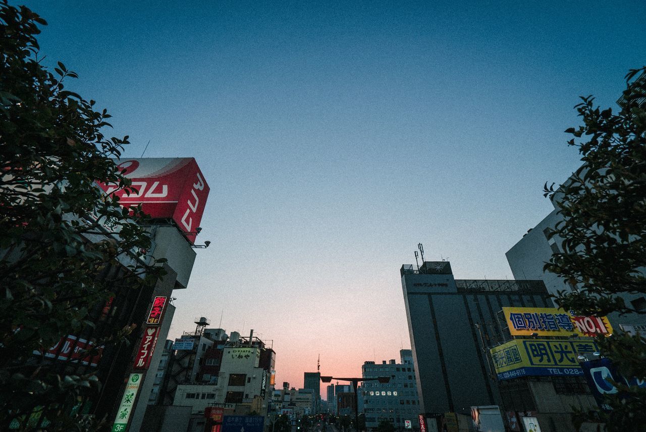 LOW ANGLE VIEW OF BUILDINGS AND STREET AGAINST SKY