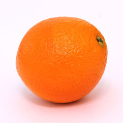 Close-up of orange apple against white background