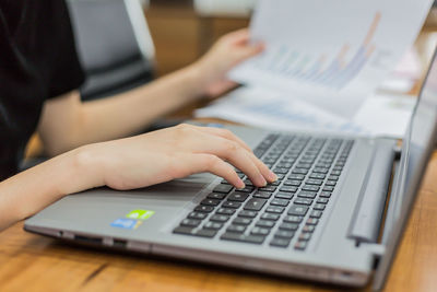 Cropped hands of businesswoman working at office