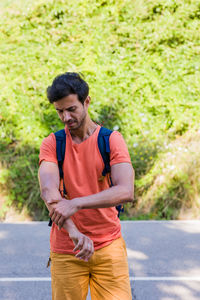 Side view of young man standing on road