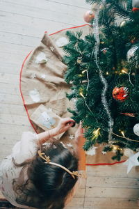 High angle view of woman decorating christmas tree