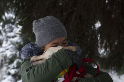 Young woman embracing dog
