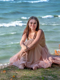 Portrait of young woman sitting at beach