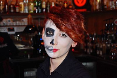 Close-up portrait of woman with face paint at bar