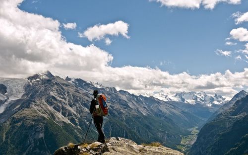 Man standing on snowcapped mountain against sky